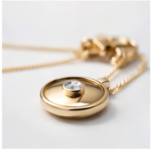 Gold necklace with a round pendant featuring a clear gemstone on a light gray background