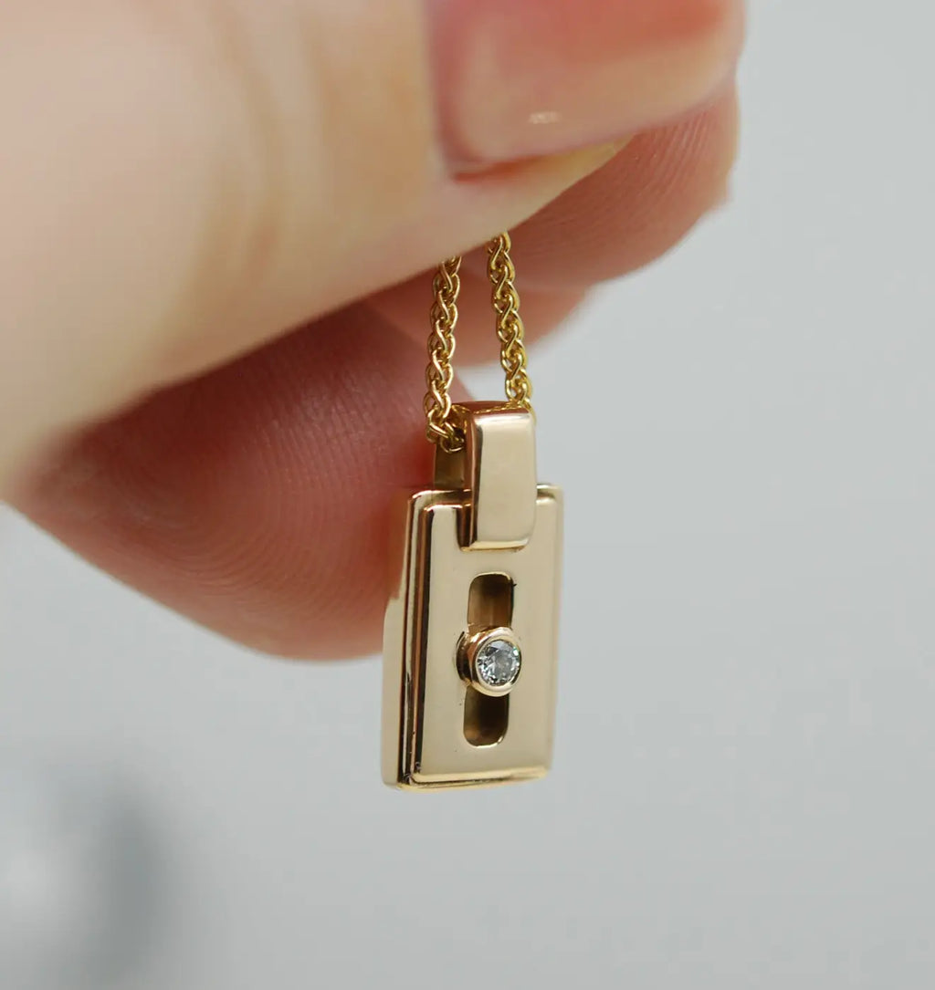 14k gold diamond pendant with central round diamond on gold chain
