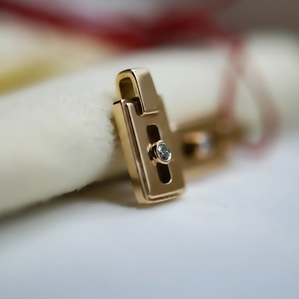 14k gold diamond pendant with gold-toned padlock clasp and central diamond