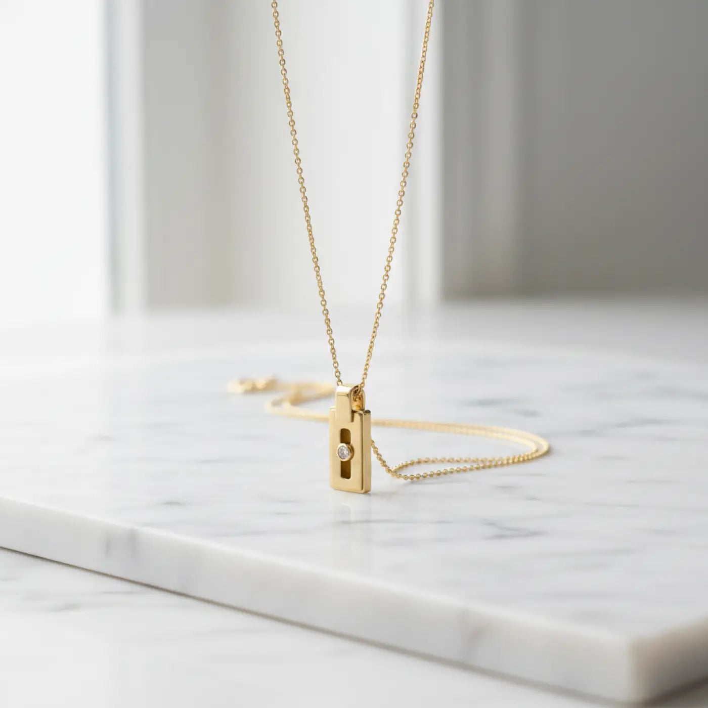 14k gold diamond pendant with gold-toned rectangular design, single diamond, vertical slit