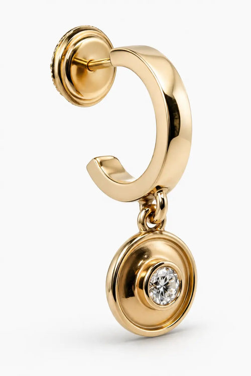 Gold hoop earring with solid 14ct yellow gold circular pendant featuring a central diamond drop design